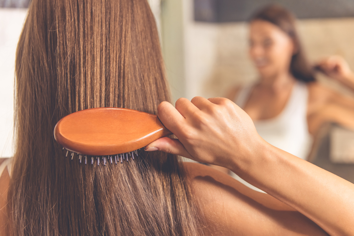 Woman brushing healthy beautiful hair and scalp